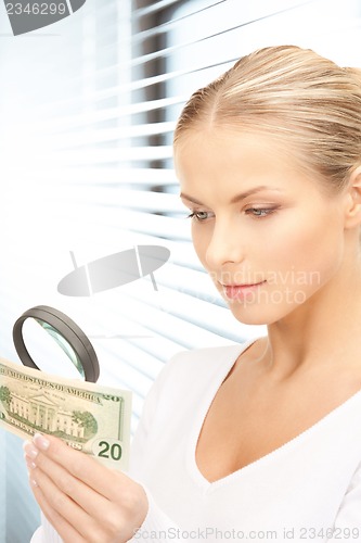 Image of woman with magnifying glass and money