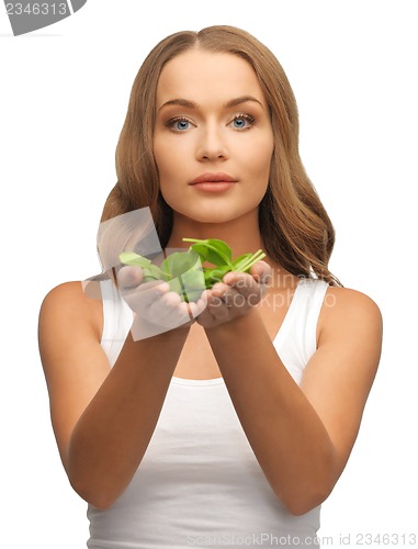 Image of woman with spinach leaves on palms