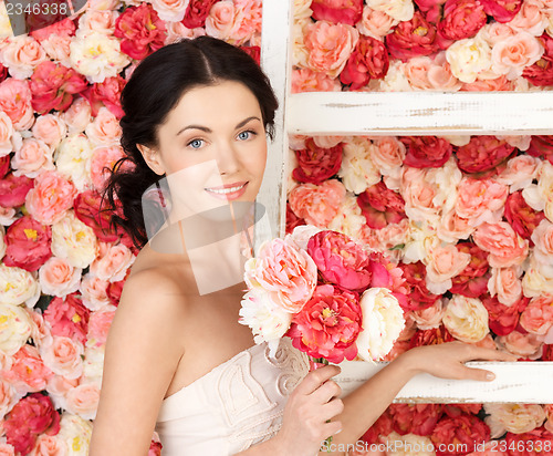 Image of woman with old ladder and background full of roses