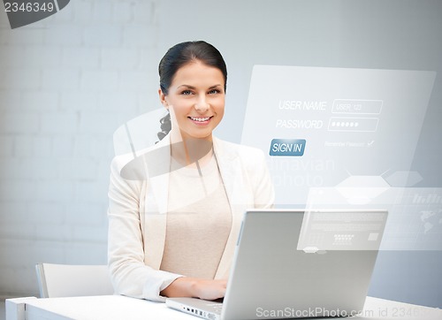 Image of woman with laptop computer and virtual screen