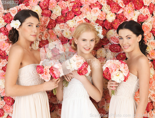 Image of three women with background full of roses