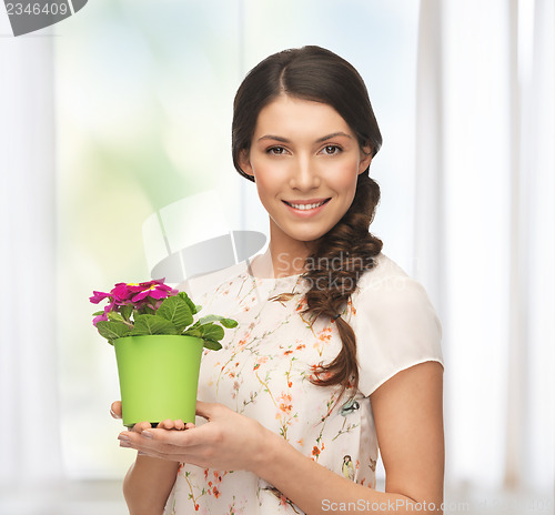 Image of lovely housewife with flower in pot