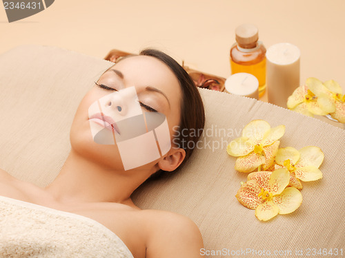 Image of woman in spa salon lying on the massage desk