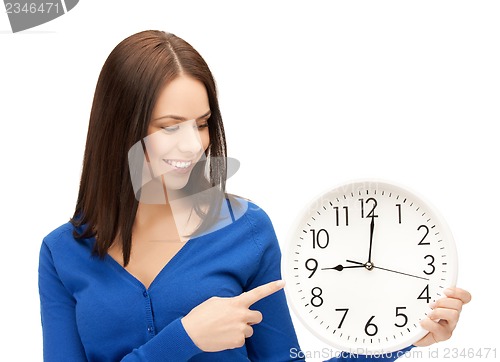 Image of businesswoman pointing her finger at wall clock