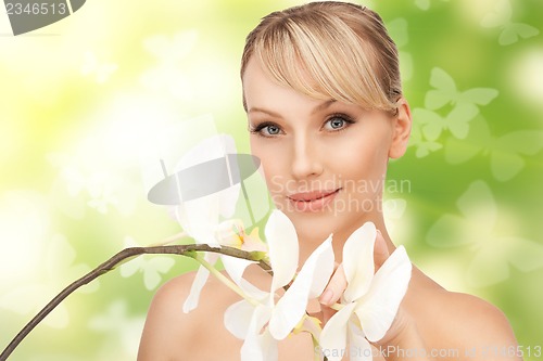 Image of beautiful woman with orchid flower and butterflies