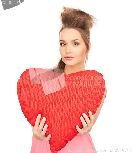 Image of happy and smiling woman with heart-shaped pillow