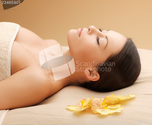 Image of woman in spa salon lying on the massage desk
