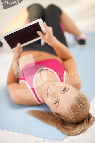 Image of woman lying on the floor with tablet pc