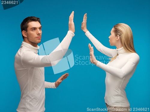 Image of man and woman working with something imaginary