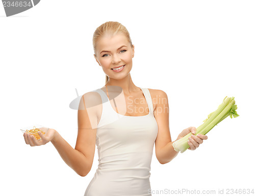 Image of woman holding bunch of celery and vitamins