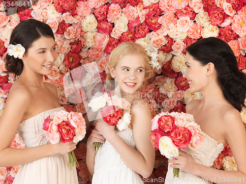 Image of three women with background full of roses