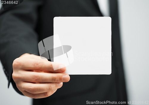 Image of man in suit holding blank card