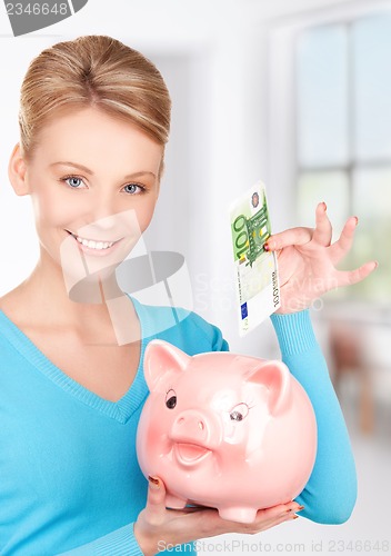 Image of lovely woman with piggy bank and money