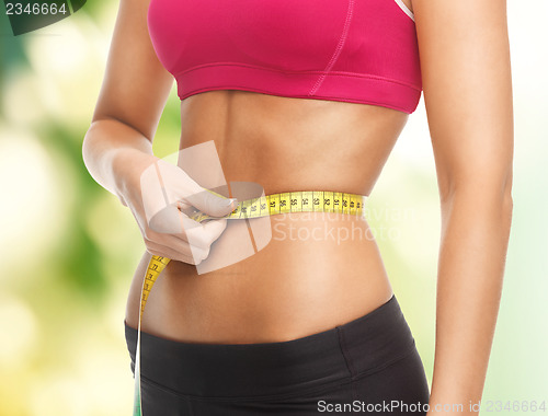 Image of trained belly with measuring tape