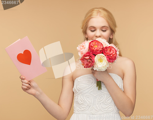 Image of girl smelling flowers and holding postcard