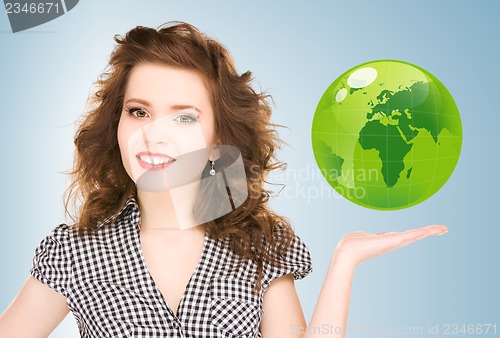 Image of woman holding green globe on her hand