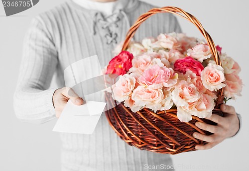 Image of man holding basket full of flowers and postcard