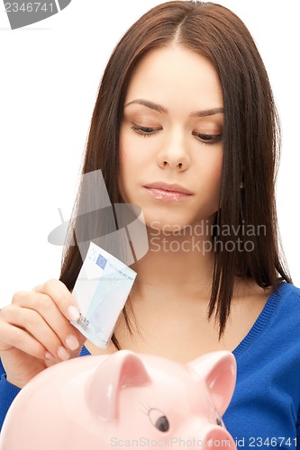 Image of lovely woman with piggy bank and money