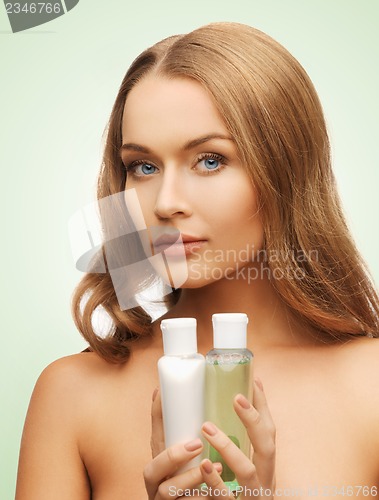 Image of woman with cosmetic bottles