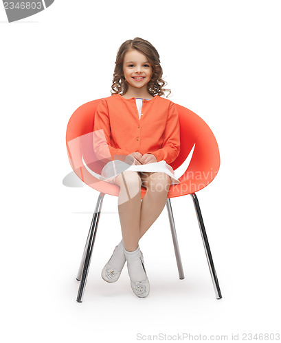 Image of pre-teen girl in casual clothes sitting on chair