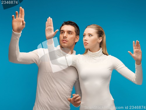 Image of man and woman working with something imaginary