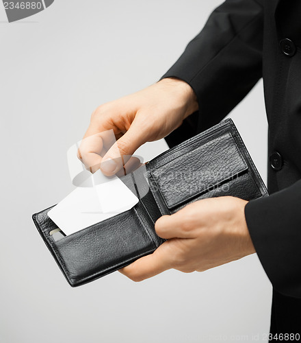 Image of man in suit holding credit card