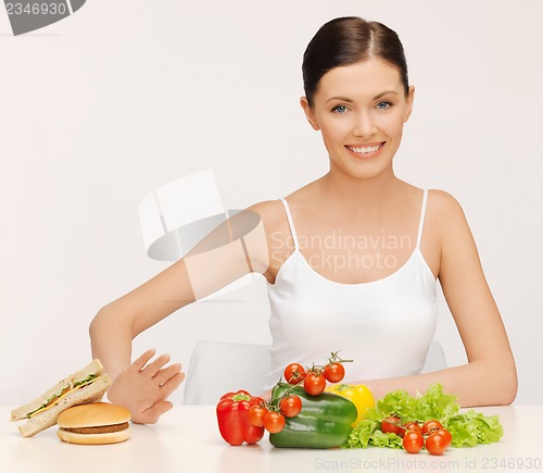 Image of woman with hamburger and vegetables