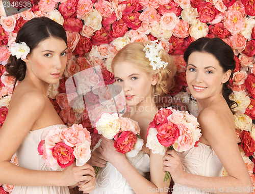 Image of three women with background full of roses