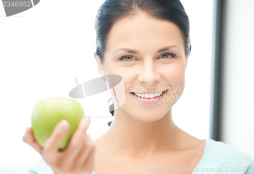 Image of woman in the kitchen with an apple