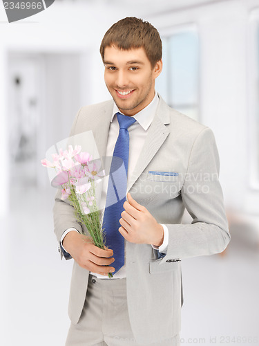 Image of handsome man with flowers in hand