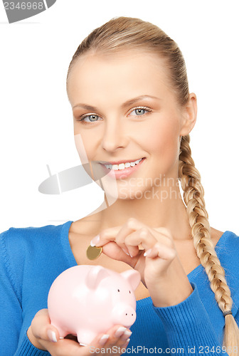 Image of lovely woman with piggy bank and money