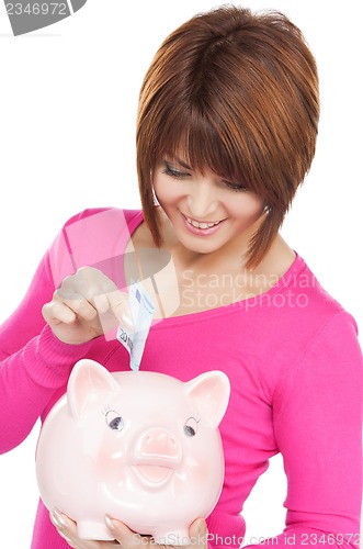 Image of lovely woman with piggy bank and money