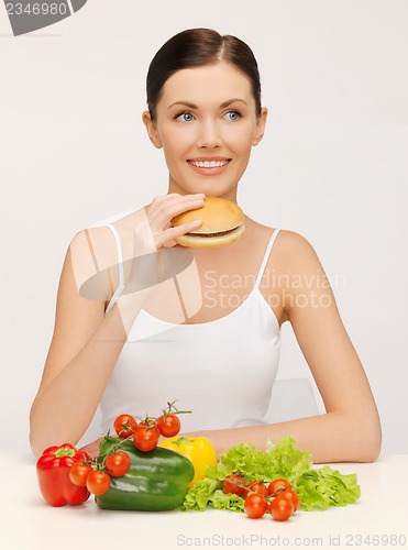 Image of woman with hamburger and vegetables