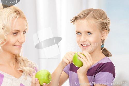 Image of mother and little girl with green apple