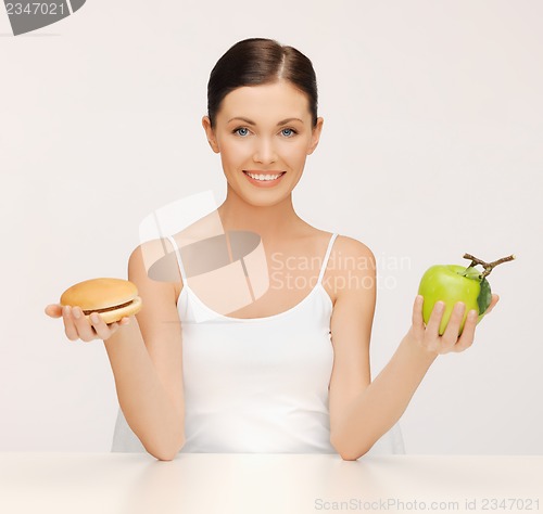 Image of woman with hamburger and apple