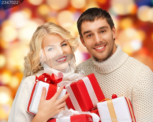 Image of family couple in a sweaters with gift boxes