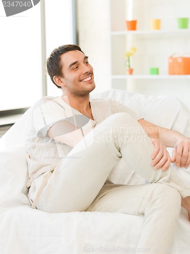 Image of handsome man sitting on the couch