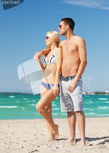 Image of happy couple in sunglasses on the beach