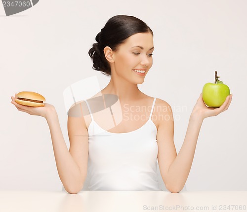 Image of woman with hamburger and apple
