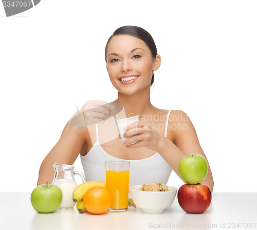 Image of young woman eating healthy breakfast