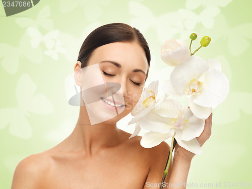 Image of smiling woman with white orchid flower