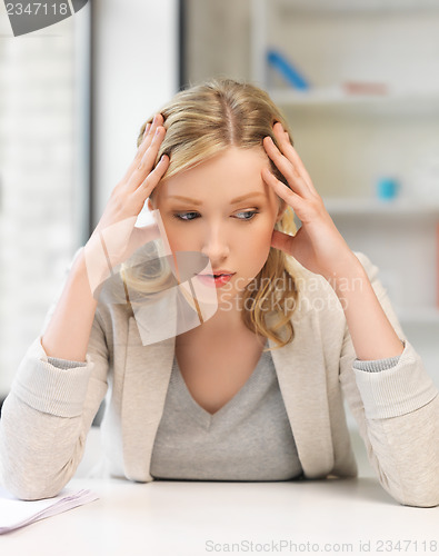 Image of bored and tired woman behind the table