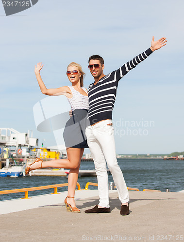 Image of Couple standing and waving in port