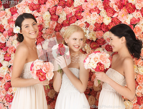 Image of three women with background full of roses