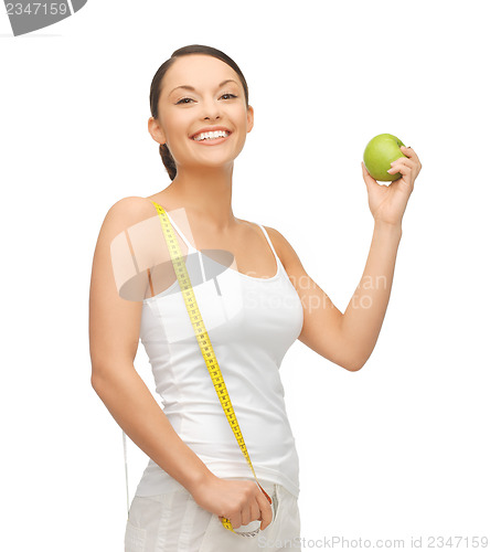 Image of sporty woman with apple and measuring tape