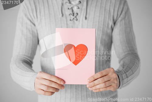 Image of man holding postcard with heart shape
