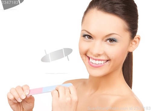 Image of smiling young woman polishing her nails