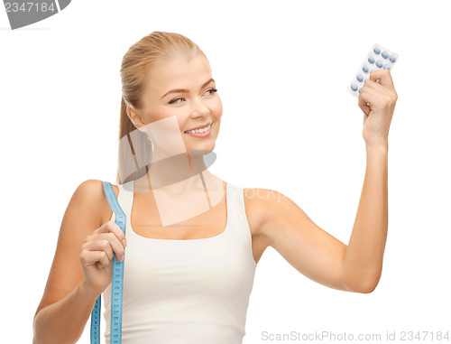 Image of woman with measuring tape and diet pills