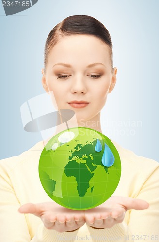 Image of woman holding green globe in her hands