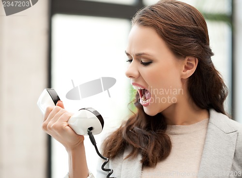 Image of angry businesswoman shouting at phone